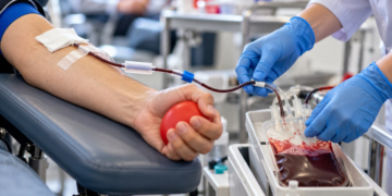 Primer plano del brazo de un donante de sangre con el material sanitario de extracción